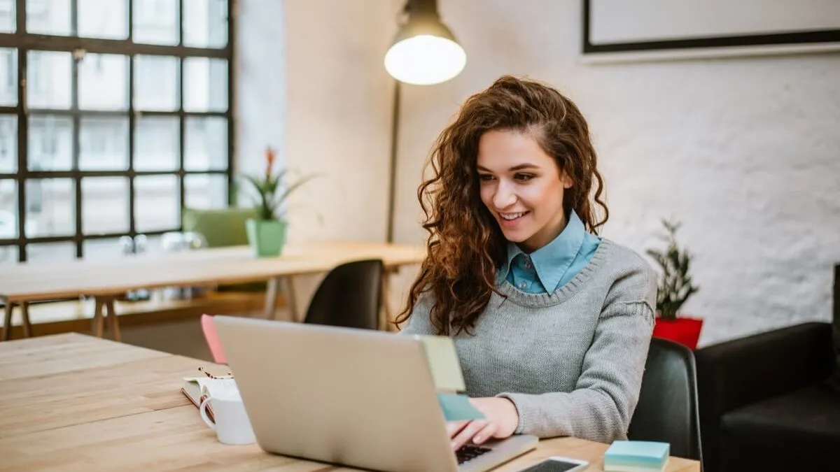 Persona che scrive al portatile in un ufficio luminoso